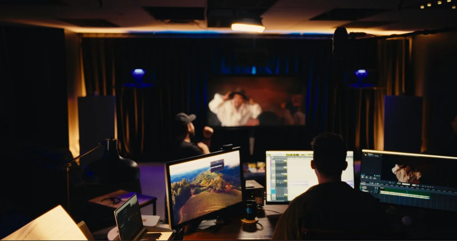 Inside the Audio Planet studio: a dark screening room with production monitors and a movie playing on screen
