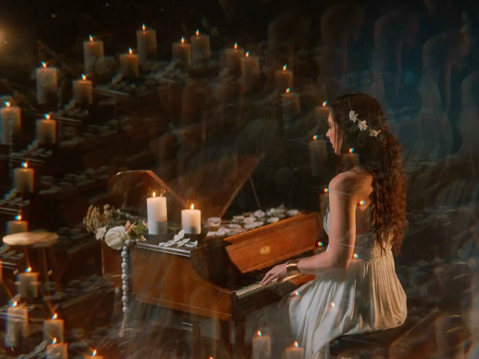 Maggie McClure playing piano in a candlelit setting